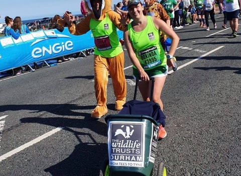 Runners pushing charity bin in Great North Run
