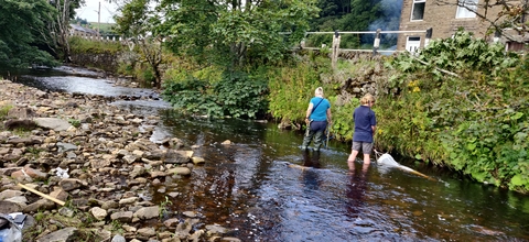 Two people taking water samples in the River Wear