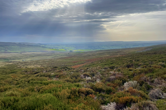 View over moorland with moody sky in background