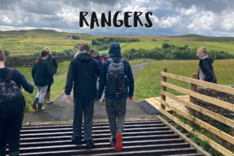 young people walking across cattle grid towards field