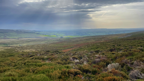 View over moorland with moody sky in background
