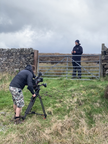 Camera person filming Durham Wildlife Trust employee at gate of nature reserve