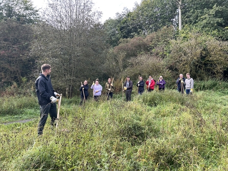 Group of people in field with scythes