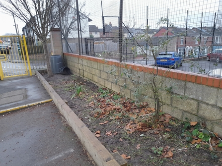 a disused planter on the edge of a school play ground. 