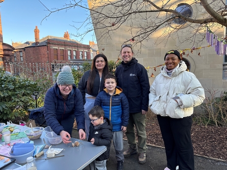 Group of six people including adults and children posing for photo at community event