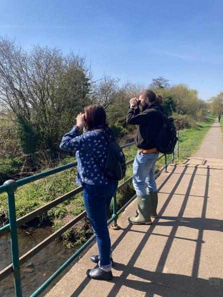 two people outside with binoculors 