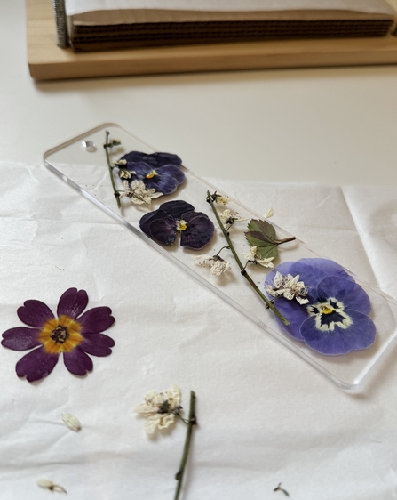Pressed flowers arranged on a clear bookmark