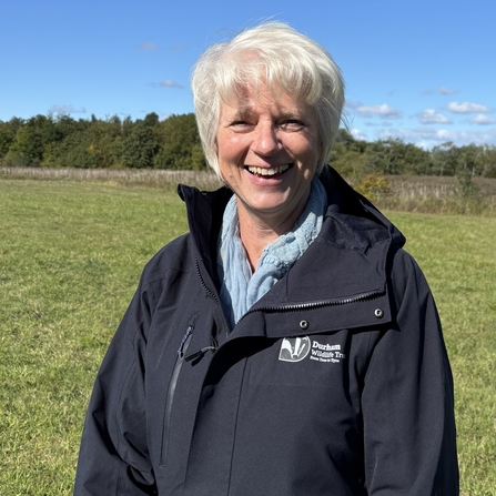 Barbara Hooper standing in front of grass field
