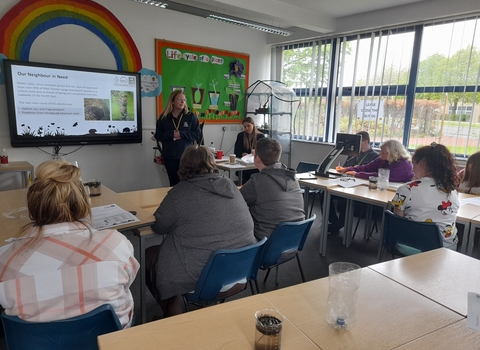 young people in classroom looking towards presentation on screen