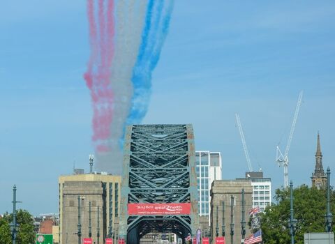 Runners crossing Tyne Bridge with Red Arrows overhead