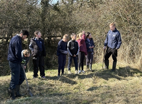 group of children and group leaders in greenspace at planting event