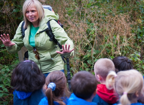 Adult in front of a group of children teaching about wildlife